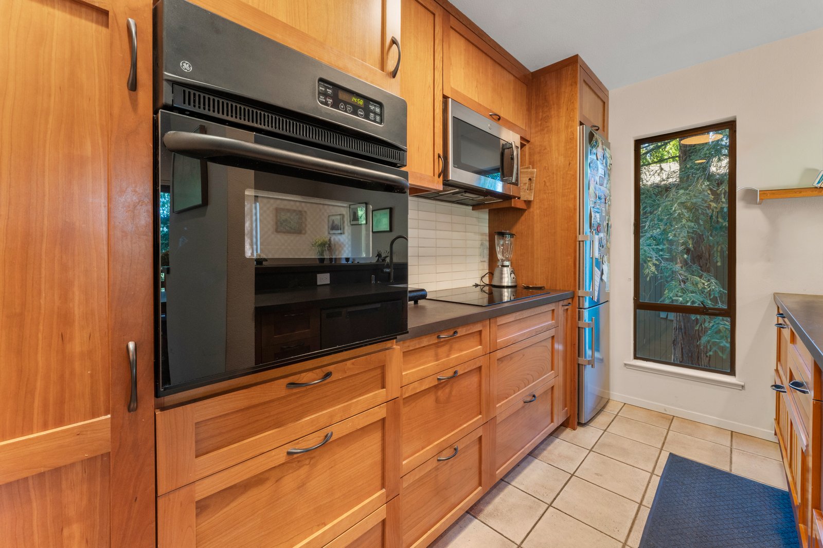 Renovated chef's kitchen with cherry cabinetry and concrete counters