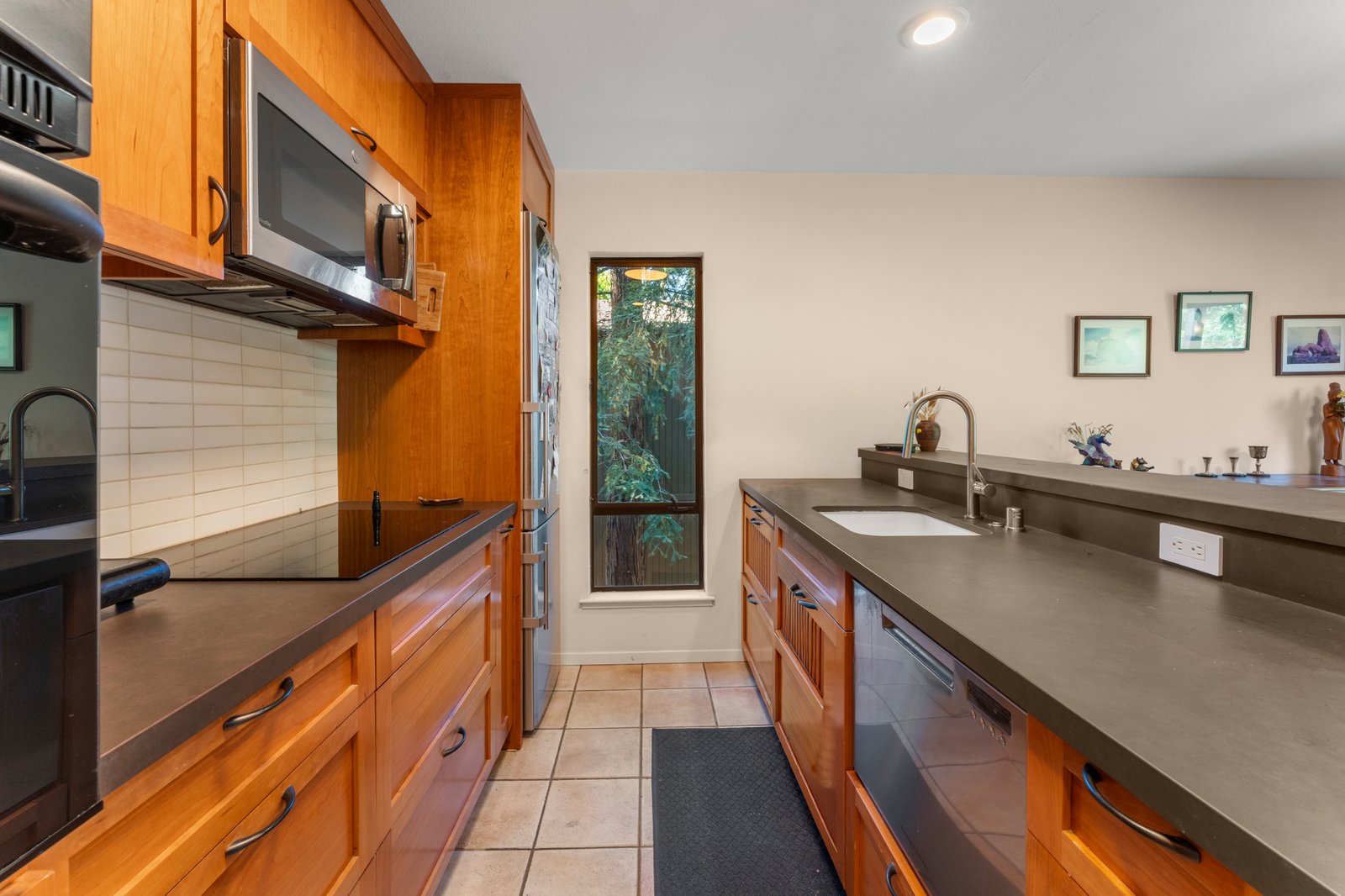 Kitchen galley with cherry cabinetry and window to the redwoods